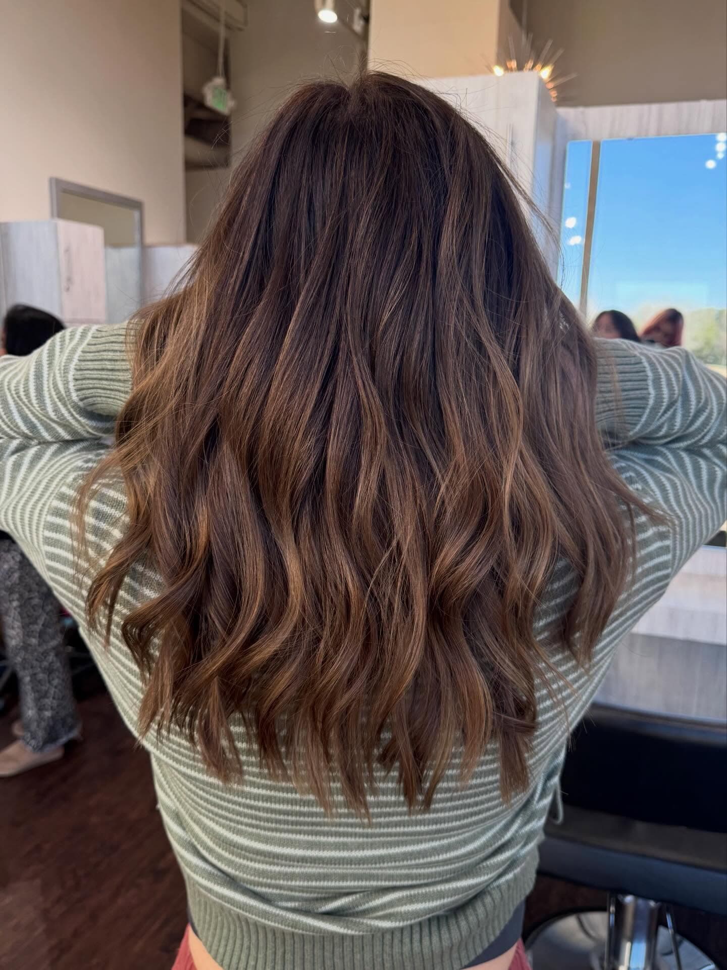 Soft, textured brunette waves with dimensional color, styled at Lee Graves Salon in Plano, TX