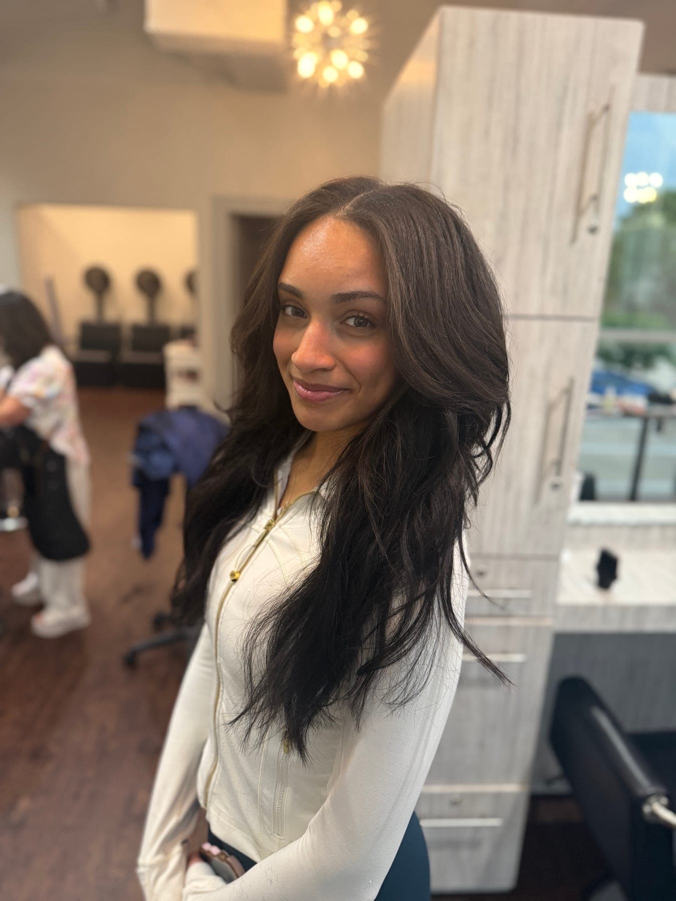 Client with long, dark hair smoothed to a sleek finish with soft movement through the ends, at Lee Graves Salon