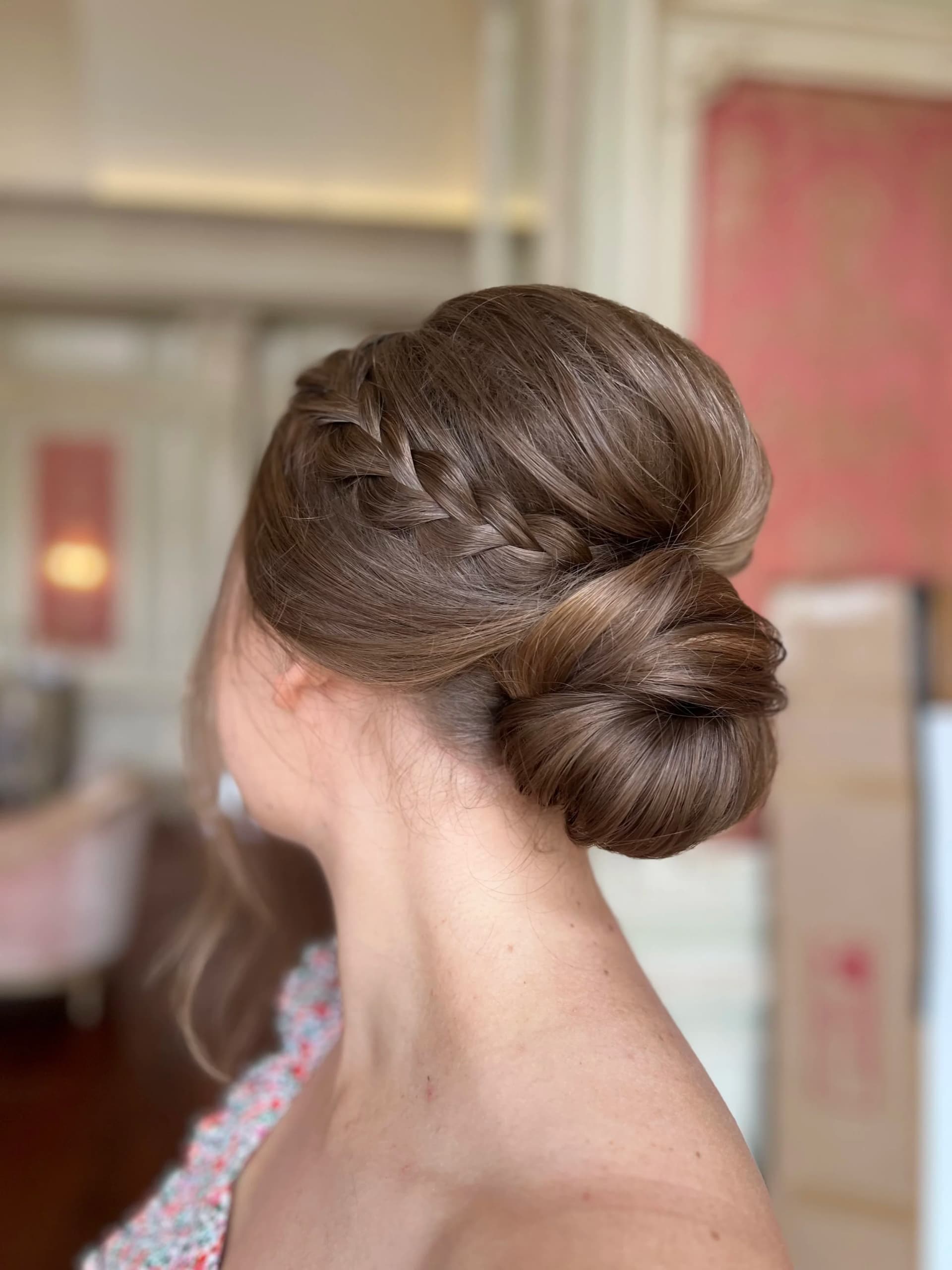 Smooth low bun with a small braid worked along one side