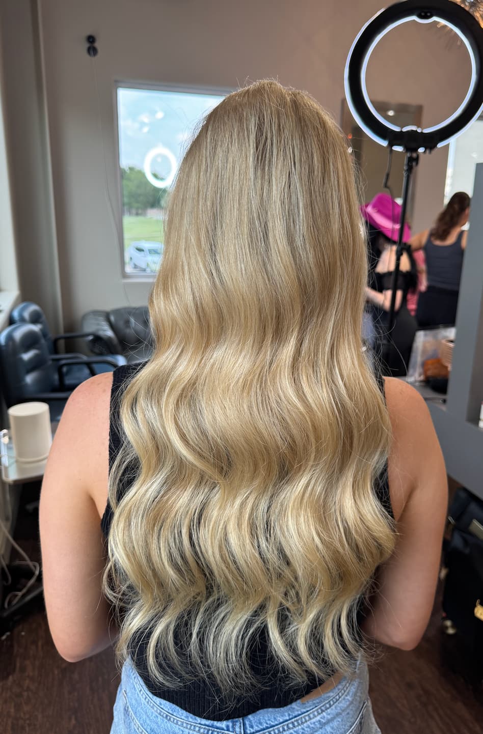 Soft, loose waves through long blonde hair, shown from the back