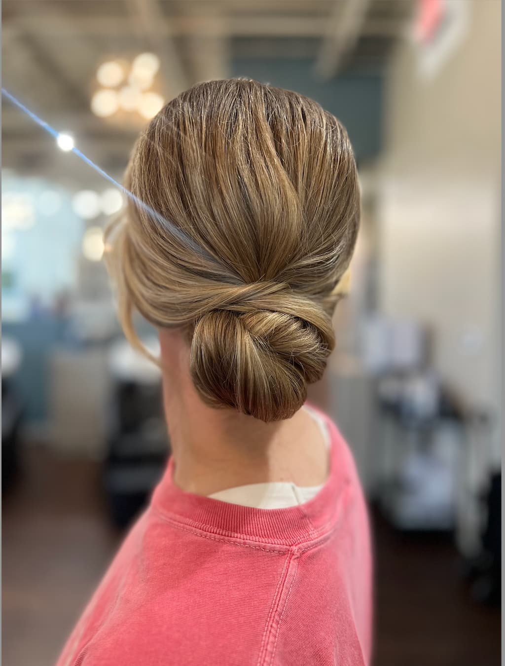 Sleek, polished low bun twisted at the nape, styled by the Lee Graves Salon team